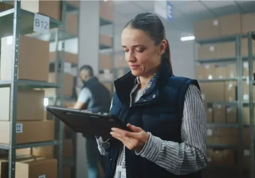 A woman is seen working in a warehouse. Dimension scanners in Peoria IL offers precise measurements.